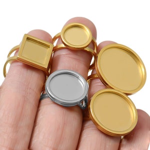 Può includere: Un set di anelli in oro e argento con bezel rotondi e quadrati. I bezel sono vuoti e pronti per essere riempiti con resina o altri materiali.