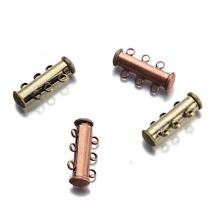 May include: Four gold and copper-toned metal magnetic clasps for jewelry making. Each clasp has three loops for attaching chains or cords.