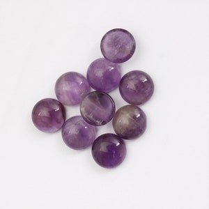May include: Eight round, purple amethyst cabochons, polished and smooth, on a white background.