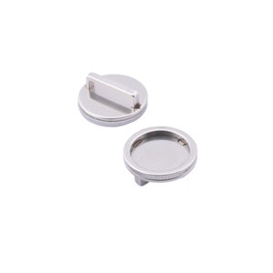 May include: Two silver-toned metal round bezel settings with a raised lip around the edge. One bezel setting has a metal loop on the top.