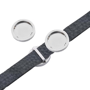 May include: Two silver round metal watch band clasps with a black leather watch band.