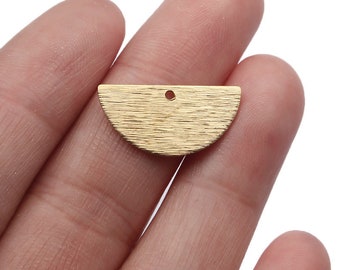 May include: Gold-toned metal half-circle charm with a textured surface and a small hole at the top for attaching to jewelry or other crafts.