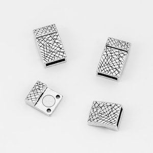 Op de afbeelding: Vier zilverkleurige metalen sluitingen met een geometrisch patroon. De sluitingen zijn ontworpen om te worden gebruikt voor het maken van sieraden.