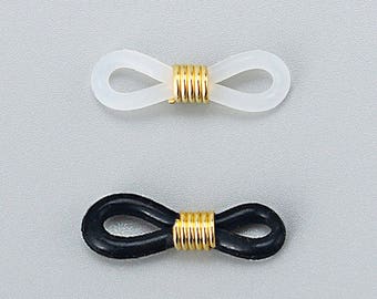 May include: Two pairs of eyeglass temple tips, one white and one black, with a gold metal connector in the center.