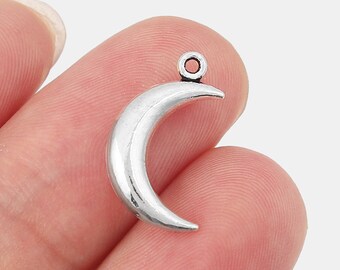 May include: Silver crescent moon charm with a jump ring at the top. The charm is about 1 inch in size.