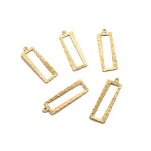 May include: Six gold-toned metal rectangular frame charms with a hammered texture. The charms have a loop at the top for attaching to jewelry or other crafts.