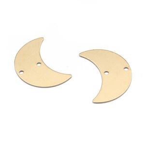 Puede incluir: Dos formas de media luna de metal de color dorado con dos agujeros cada una.