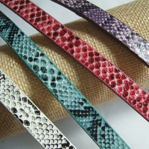 Może przedstawiać: Cztery skórzane paski w różnych kolorach z wzorem skóry węża. Paski są białe, turkusowe, różowe i fioletowe.