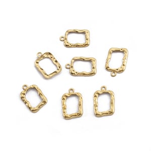 May include: Seven gold-toned metal rectangular frames with a textured surface. Each frame has a small loop at the top for hanging.