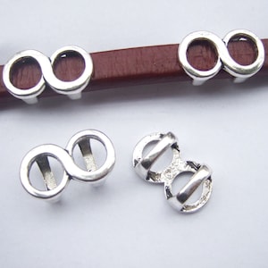 Puede incluir: Tres abalorios de plata con símbolo de infinito para pulseras de cuero. Los abalorios están diseñados para deslizarse sobre una correa de cuero.