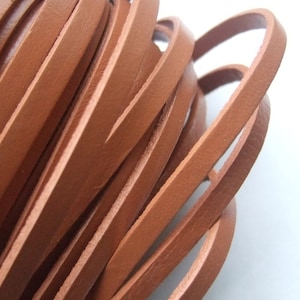May include: Close-up of a pile of brown leather cord, showing the texture and detail of the material.