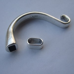 May include: Silver-toned metal clasp with a black square insert and a matching silver-toned metal loop.