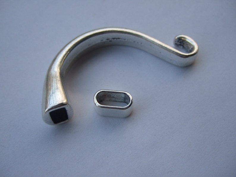 May include: Silver-toned metal clasp with a black square insert and a matching silver-toned metal loop.