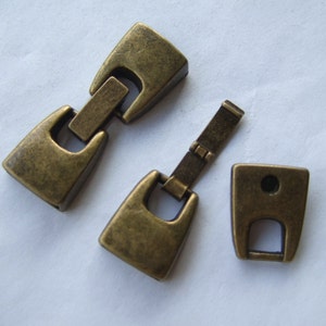 May include: Three antique gold-toned metal clasps for jewellery making. The clasps are in different shapes and sizes.