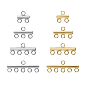 May include: Four different sizes of silver and gold metal connector clasps for jewelry making. The clasps have a bar with multiple loops for attaching chains or cords.