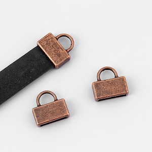 May include: Three antique copper-toned metal end caps for leather straps. The end caps have a rectangular shape with a small loop on top.