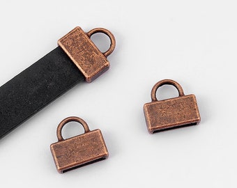 May include: Three antique copper-toned metal end caps for leather straps. The end caps have a rectangular shape with a small loop on top.