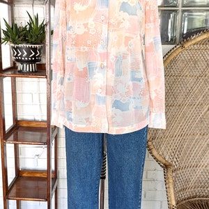 Peut inclure: Une chemise &agrave; manches longues &agrave; boutons avec un imprim&eacute; abstrait rose et bleu. La chemise a un col et une coupe d&eacute;contract&eacute;e.