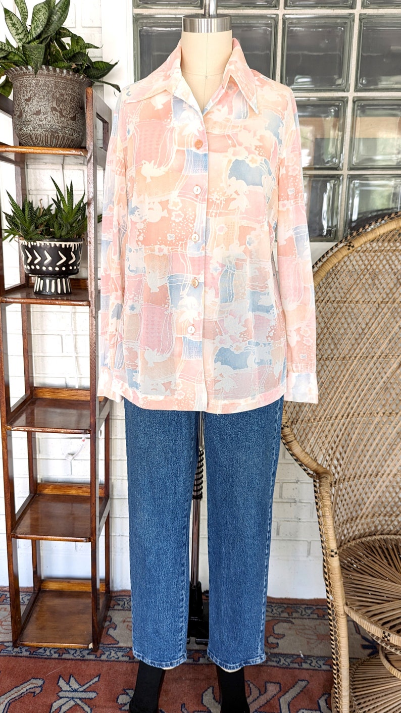 Peut inclure: Une chemise &agrave; manches longues &agrave; boutons avec un imprim&eacute; abstrait rose et bleu. La chemise a un col et une coupe d&eacute;contract&eacute;e.