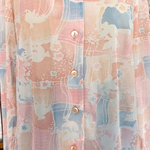 Peut inclure: Une chemise &agrave; manches longues &agrave; boutons avec un imprim&eacute; abstrait rose p&acirc;le, bleu et blanc.