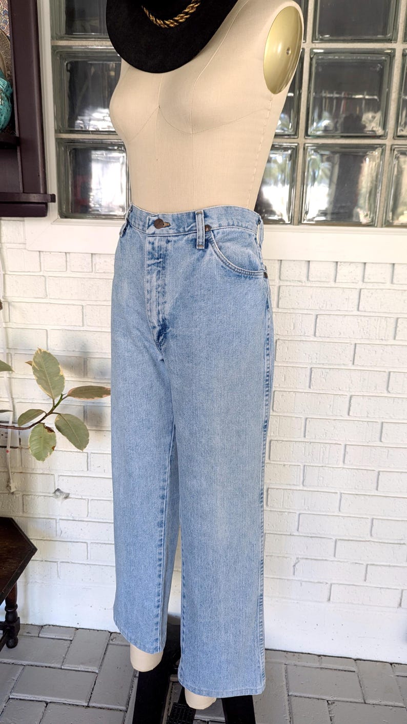 K&ouml;nnte beinhalten: Hellblaue Jeans aus Denim mit hoher Taille und geradem Bein. Die Jeans haben einen Knopfverschluss und f&uuml;nf Taschen.