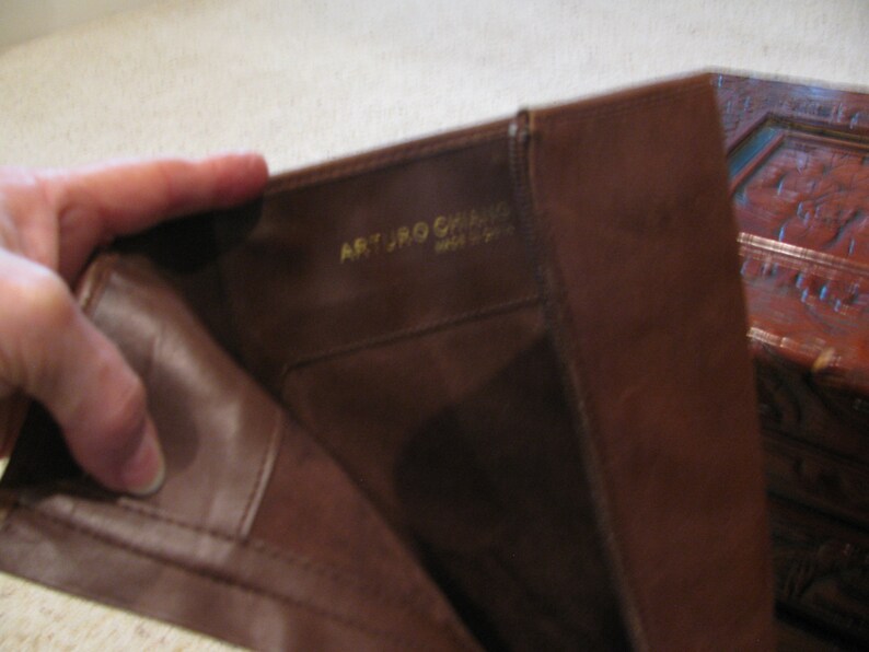 May include: Close-up of the inside of a brown leather boot with the text "ARTURO  GHIRARDI  MADE IN ITALY" in gold lettering.