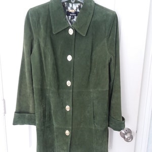 May include: A green suede jacket with gold buttons. The jacket has a collared neckline and long sleeves.