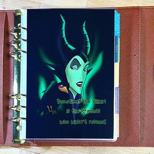 Puede incluir: Una agenda negra y verde con una cita que dice "Sometimes the Villain is the Princess who wasn't rescued". La agenda presenta una ilustraci&oacute;n de Mal&eacute;fica de La Bella Durmiente de Disney.