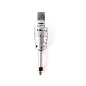 May include: A silver Mitutoyo micrometer head featuring a knurled top adjustment knob, a cylindrical body with black numerical markings, and a graduated scale. The device displays the text Mitutoyo and .0001 inch on its metallic surface.