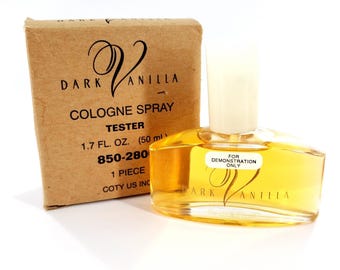 May include: A bottle of Dark Vanilla cologne spray with a matching cardboard box. The bottle is filled with a golden liquid and has a white cap. The box reads "Dark Vanilla Cologne Spray Tester 1.7 fl oz."