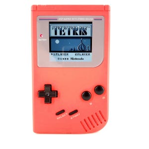 May include: A coral-colored handheld gaming device with a screen displaying the Tetris game. The device has a directional pad, select and start buttons, and black buttons. The text "TETRIS" and "©1989 Nintendo" are visible on the screen.