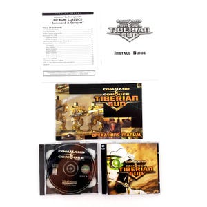 May include: A collection of Command & Conquer: Tiberian Sun CD-ROM game components. Includes an install guide, operations manual, and two CD-ROM discs. The game's logo and title are prominently displayed on the packaging.