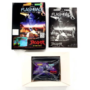 May include: A Flashback: The Quest for Identity video game set for the Atari Jaguar, including a black cardboard box with cover art, a printed game manual, and a plastic-wrapped game cartridge, all featuring the game title and branding.