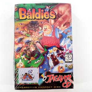 May include: A sealed "Baldie's" video game for the Atari Jaguar CD. The box art features a cartoon character in red overalls, a monster, and various colorful scenes. The game is rated for ages 6+.
