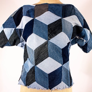 May include: A short-sleeved top made from denim fabric with a geometric pattern of blue and black squares.