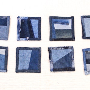 以下が含まれることがあります： 青色のパッチワークのデザインが施された、正方形のデニムコースターが8つあります。