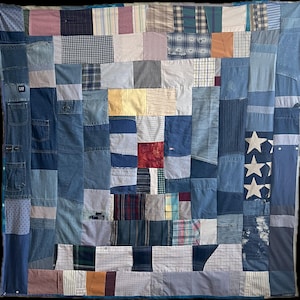 May include: A patchwork quilt composed of various denim and fabric squares in shades of blue, white, and red. The quilt features denim pockets, plaid, and star patterns, creating a rustic, handcrafted aesthetic. The quilt is a large square.