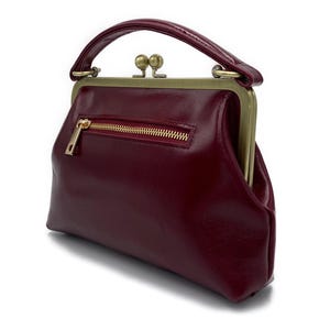 K&ouml;nnte beinhalten: Eine wei&szlig;e Keramik-Tasse mit schwarzem Henkel und dem Text "But First, Coffee" in schwarzer, fetter Schrift. Die Tasse steht auf einer wei&szlig;en Oberfl&auml;che. Die Tasse ist wahrscheinlich f&uuml;r Hei&szlig;getr&auml;nke.