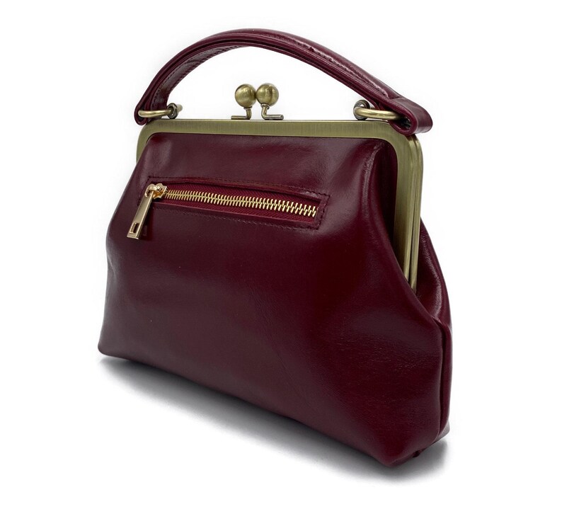 K&ouml;nnte beinhalten: Eine wei&szlig;e Keramik-Tasse mit schwarzem Henkel und dem Text "But First, Coffee" in schwarzer, fetter Schrift. Die Tasse steht auf einer wei&szlig;en Oberfl&auml;che. Die Tasse ist wahrscheinlich f&uuml;r Hei&szlig;getr&auml;nke.