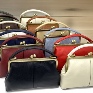 May include: A row of 10 vintage-style purses in various colors, including green, brown, white, red, blue, and cream. Each purse has a unique design and features a gold-toned clasp and handle.