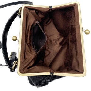 Puede incluir: Un bolso negro con exterior texturizado y un marco de metal dorado con cierre de broche. El interior est&aacute; forrado con tela marr&oacute;n y cuenta con un bolsillo con cremallera. Una correa negra para el hombro est&aacute; sujeta al lateral del bolso.