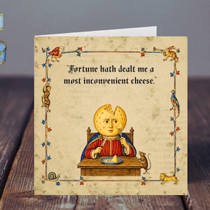 May include: A square greeting card featuring a medieval-style illustration of a person with a round cheese head sitting at a table, holding a knife and fork. The text reads, "Fortune hath dealt me a most inconvenient cheese." The border includes small animals.