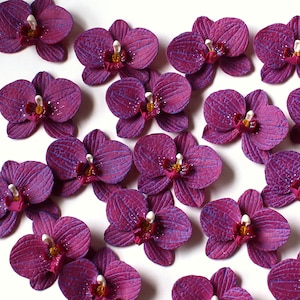 Handmade polymer clay burgundy orchid beads for making jewelry. You can use these burgundy orchid beads for your own projects. They’re perfect for making your own jewelry. You can create earrings, necklaces, rings, pendants, or hair accessories. You can also use these orchid beads to decorate surfaces, such as picture frames.
