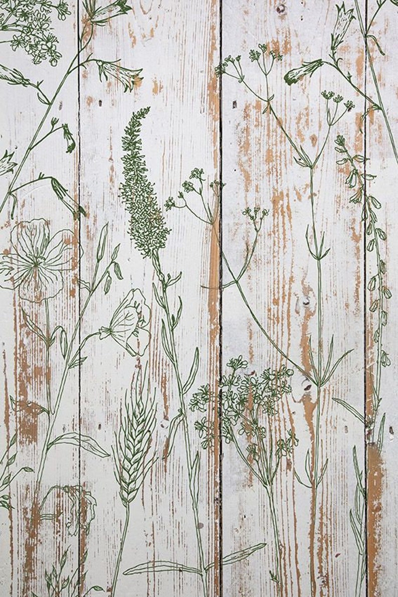 May include: A close-up of a white wooden surface with a distressed finish, featuring a repeating pattern of green botanical line drawings. The design includes various flowers, leaves, and stems, creating a natural, rustic aesthetic.