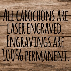 May include: A wooden sign with black text that reads "All cabochons are laser engraved. Engravings are 100% permanent."