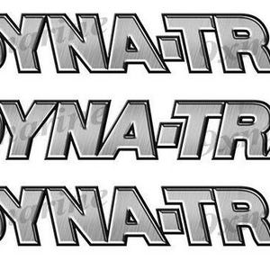 May include: Three Dyna-Trak decals. Each decal features the text "DYNA-TRAK" in a metallic silver color. The left side of each decal has a design with blue, orange, and white elements. The decals are on a white background.