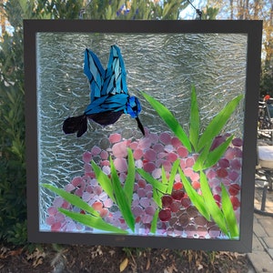 Stained glass mosaic hummingbird in the hydrangeas