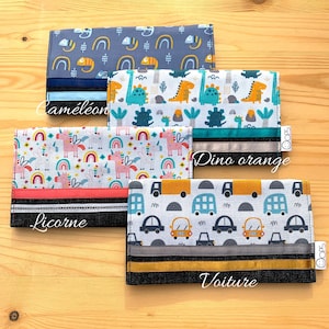 May include: Four different fabric pouches with colourful patterns and black trim. The pouches are labelled "Caméléon", "Dino orange", "Licorne", and "Voiture".