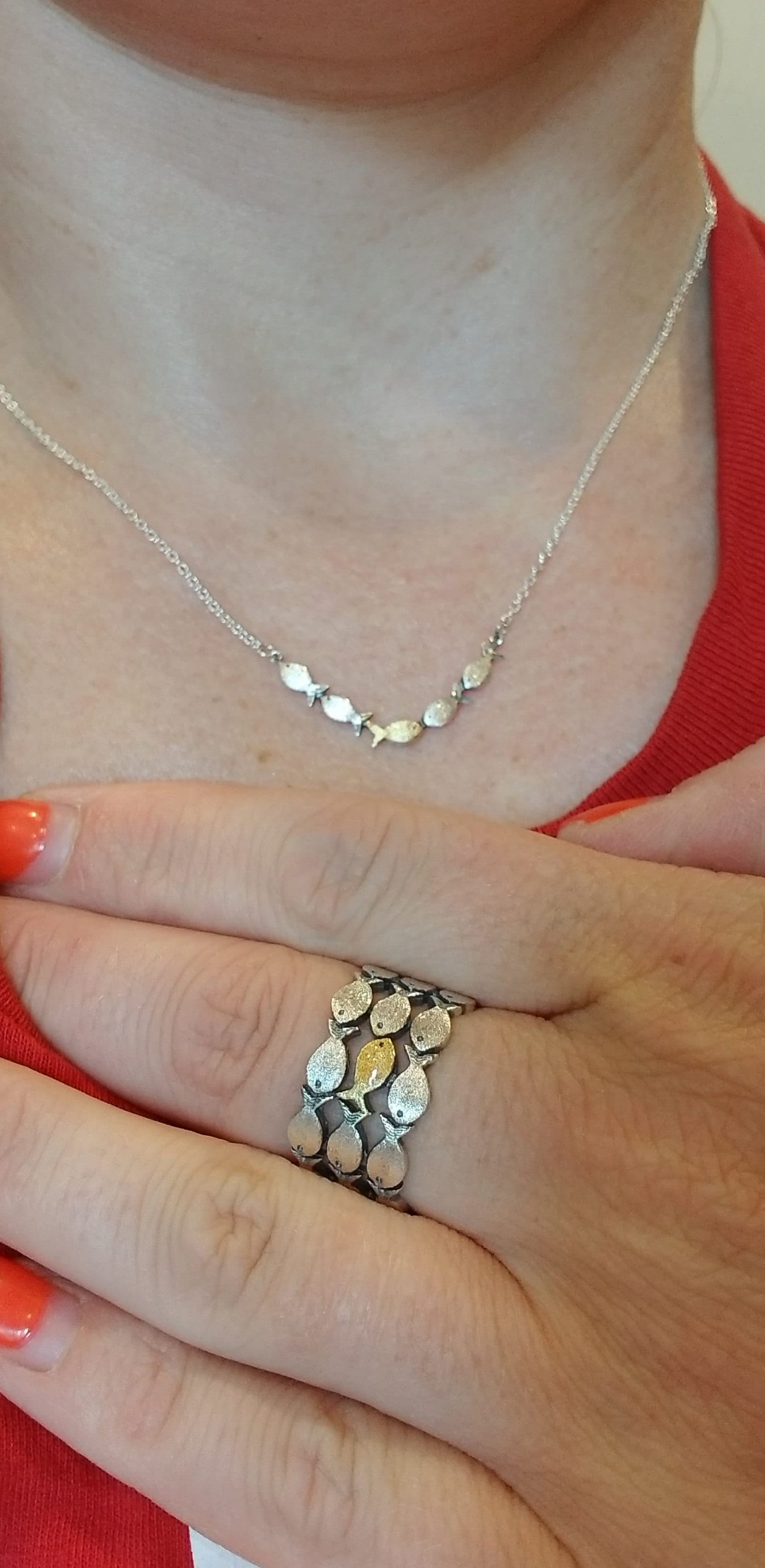 Swimming against the current. Dainty silver necklace. School of fish with one golden enameled fish swimming upstream. Gift for her.