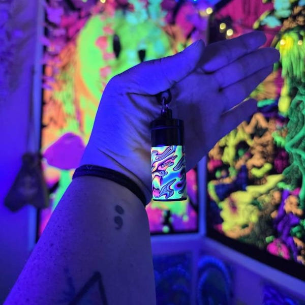 uv stash box held aloft under UV blacklight